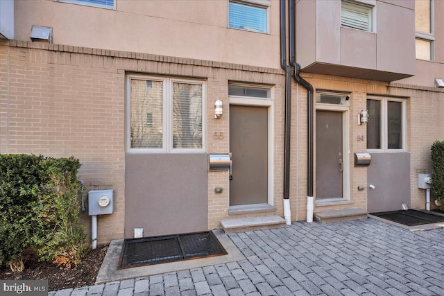 property entrance featuring brick siding