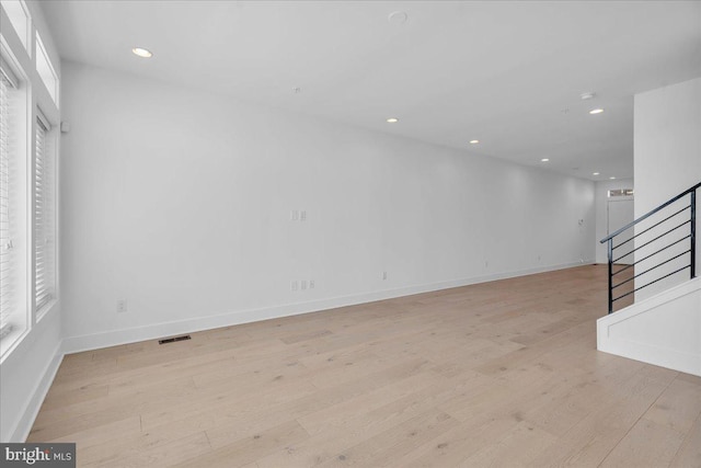 unfurnished living room with recessed lighting, visible vents, stairway, and light wood finished floors