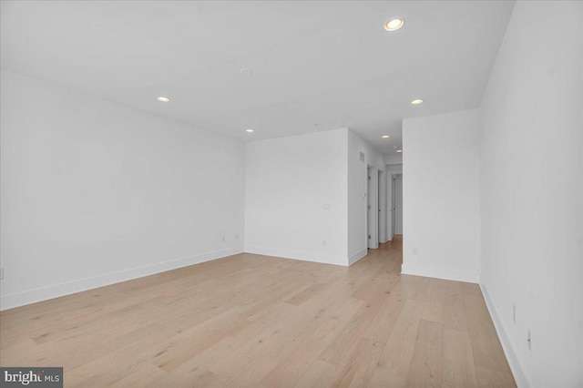 empty room with recessed lighting, baseboards, and light wood-style floors