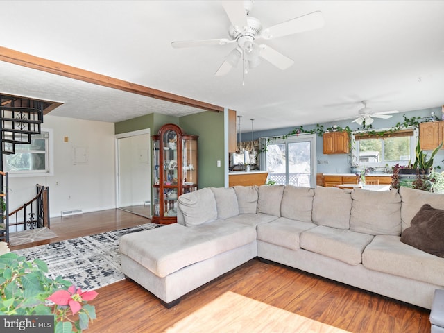 living room featuring visible vents, light wood finished floors, and ceiling fan