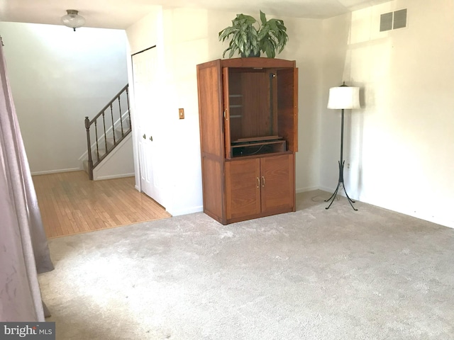 interior space with visible vents, stairway, and carpet