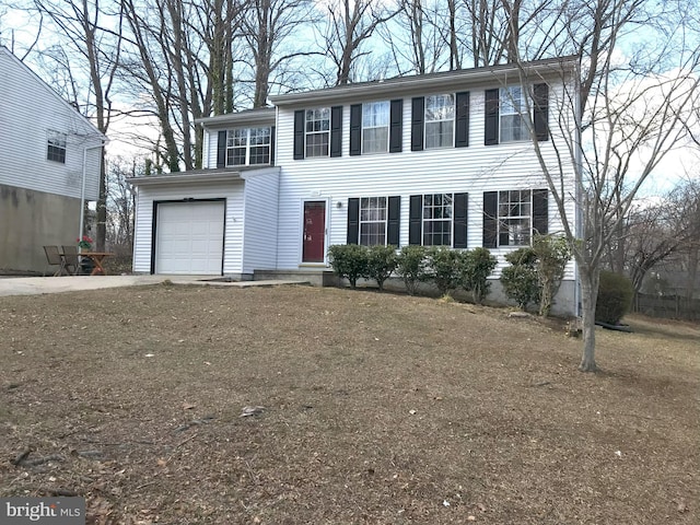 colonial-style house with concrete driveway and a garage