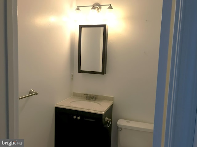 half bathroom featuring toilet and vanity