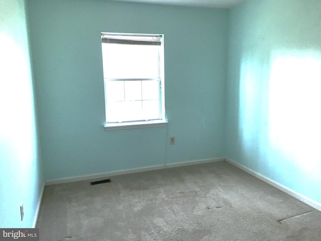 unfurnished room with visible vents, baseboards, and carpet