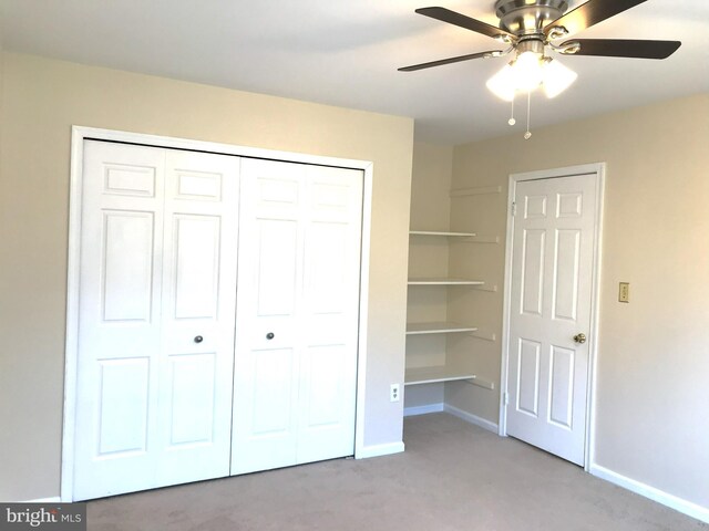 unfurnished bedroom with a closet, baseboards, ceiling fan, and carpet flooring