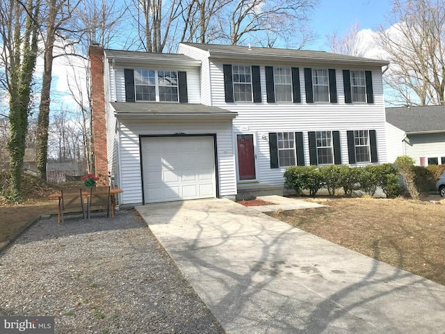 view of front of house with a chimney, concrete driveway, and a garage