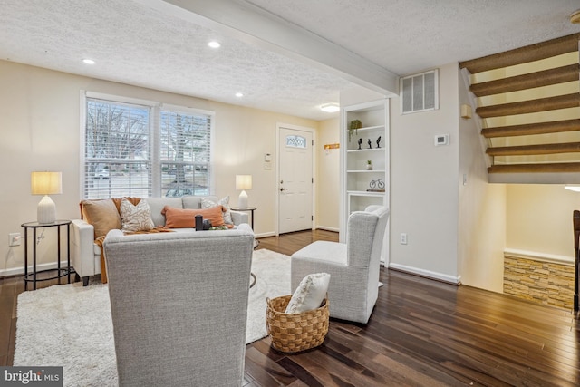 living area featuring visible vents, a textured ceiling, and dark wood finished floors