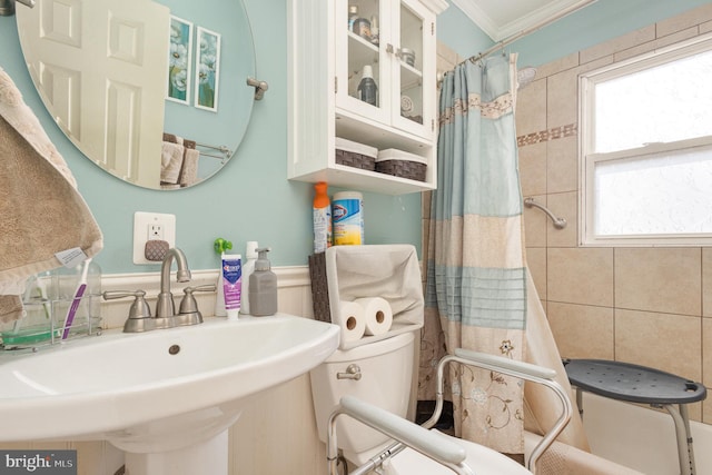 full bathroom with curtained shower, ornamental molding, and a sink