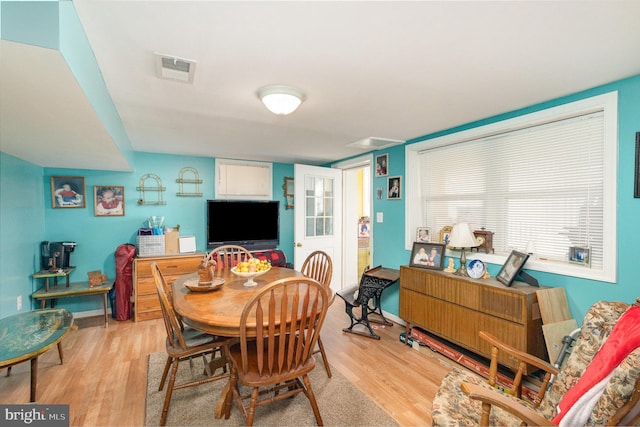 dining space featuring wood finished floors, visible vents, and baseboards