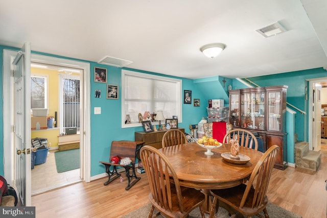 dining room featuring visible vents, baseboards, and wood finished floors