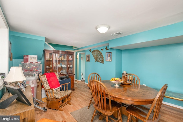 dining area with visible vents, baseboards, and wood finished floors