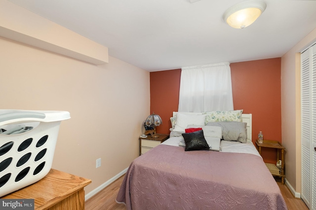 bedroom featuring a closet, baseboards, and light wood-style floors