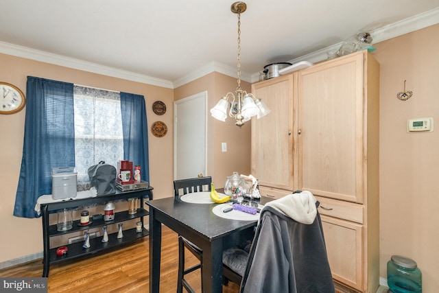 dining area featuring baseboards, crown molding, an inviting chandelier, and wood finished floors