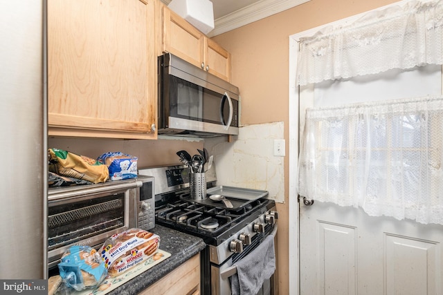 kitchen with light brown cabinetry, dark countertops, appliances with stainless steel finishes, and crown molding