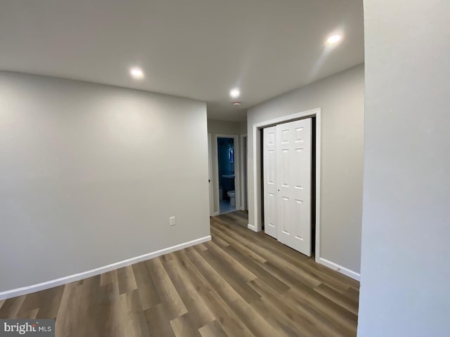 empty room with recessed lighting, baseboards, and wood finished floors