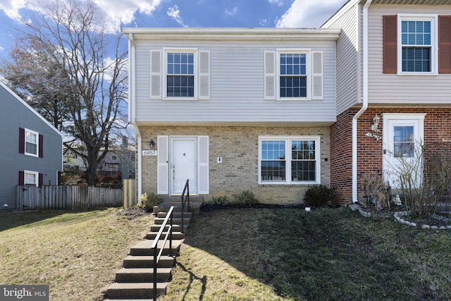 multi unit property featuring brick siding, a front yard, and fence