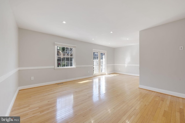 unfurnished room with visible vents, hardwood / wood-style floors, recessed lighting, french doors, and baseboards