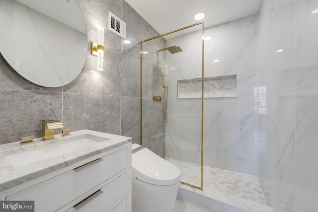 full bath with vanity, visible vents, a marble finish shower, tile walls, and toilet