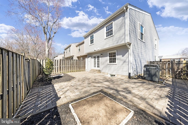 rear view of house with a garden, a patio, a fenced backyard, and entry steps