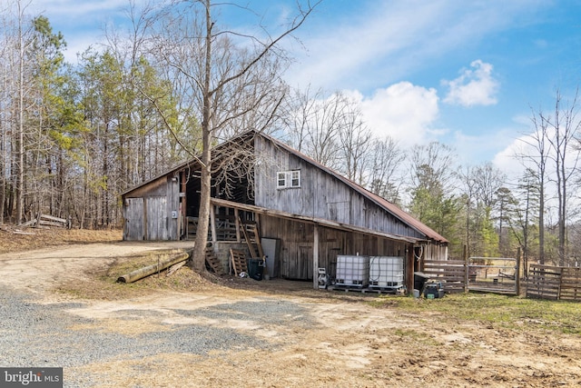 view of side of property with a garage, an outbuilding, a barn, and fence