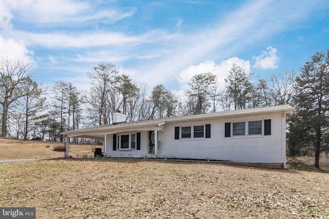 single story home with brick siding and a chimney