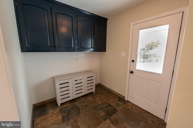 doorway featuring stone finish flooring and baseboards