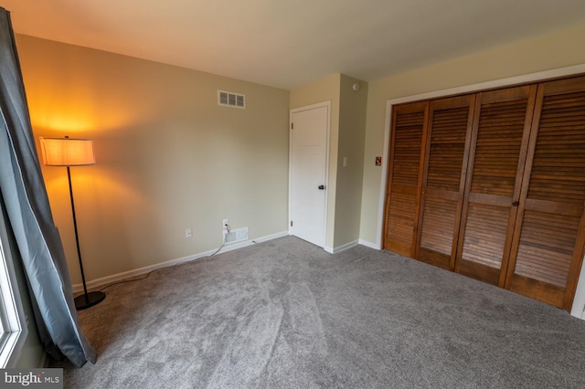 unfurnished bedroom with visible vents, baseboards, carpet, and a closet