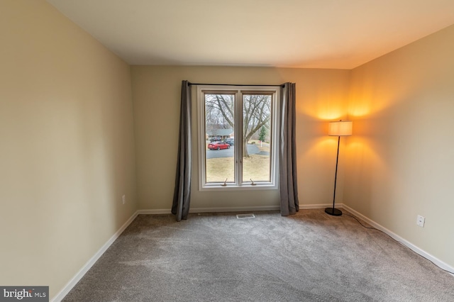 spare room with visible vents, baseboards, and carpet