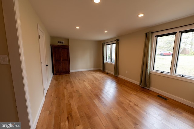 unfurnished room with light wood-type flooring, visible vents, and recessed lighting