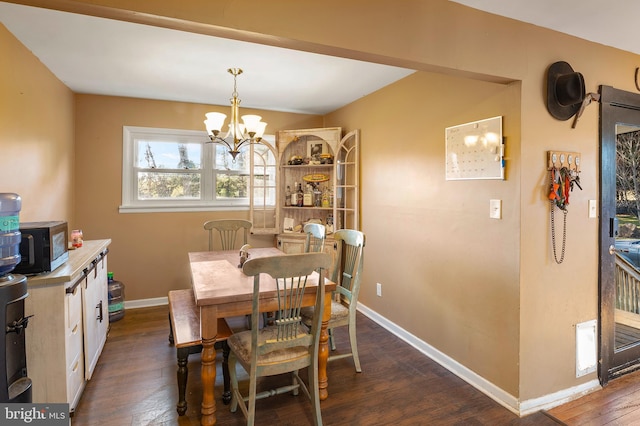 dining space with baseboards, a notable chandelier, and dark wood-style floors