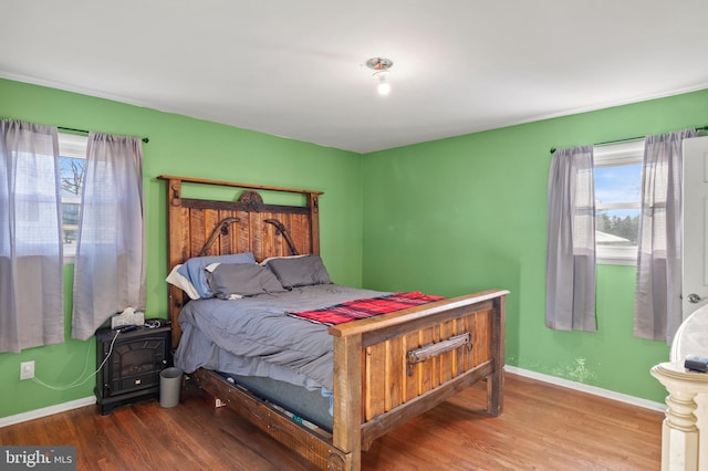 bedroom with baseboards and wood finished floors