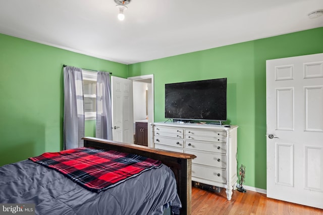 bedroom featuring baseboards and wood finished floors