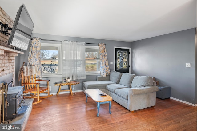 living room featuring baseboards, wood finished floors, and a fireplace