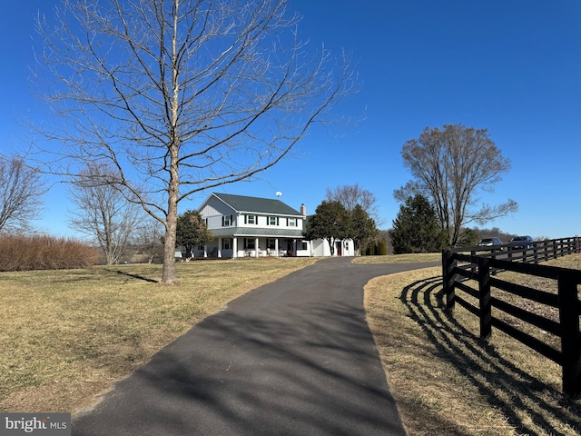 view of front of property featuring a porch, metal roof, a front yard, and fence