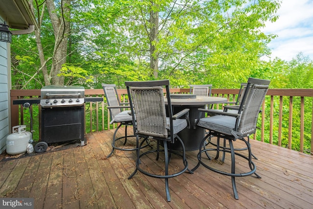 wooden terrace with outdoor dining space and grilling area