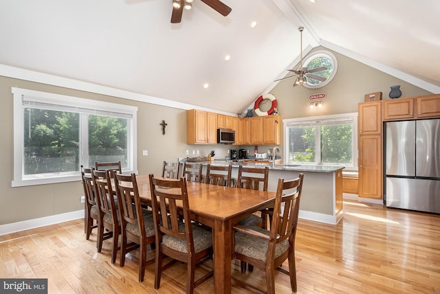 dining room with light wood finished floors, beam ceiling, baseboards, and a ceiling fan