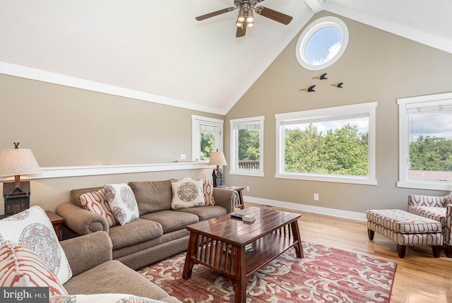 living room featuring light wood-style floors, high vaulted ceiling, baseboards, and a ceiling fan