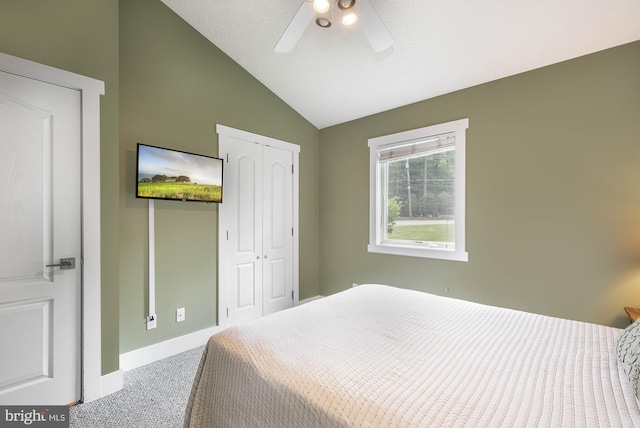 carpeted bedroom featuring baseboards, a ceiling fan, vaulted ceiling, and a closet