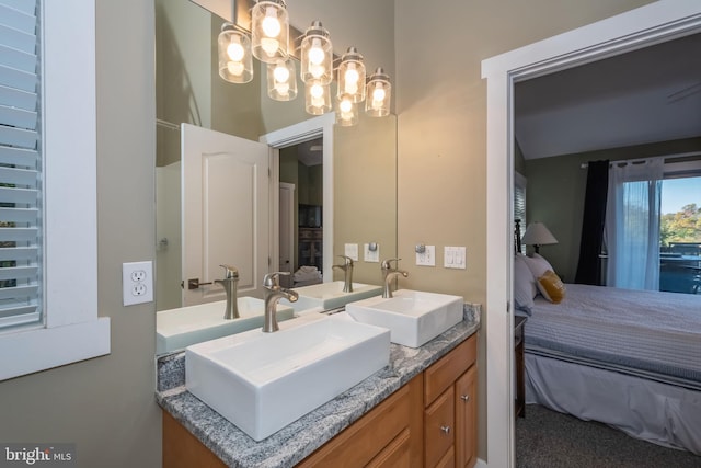 full bath with double vanity, ensuite bath, and a sink