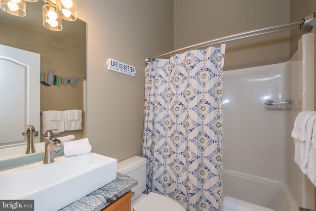 bathroom with curtained shower, vanity, and toilet