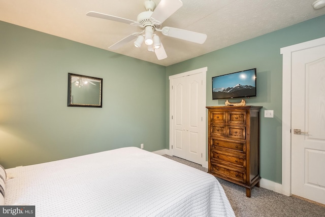 carpeted bedroom featuring baseboards, a textured ceiling, a ceiling fan, and a closet