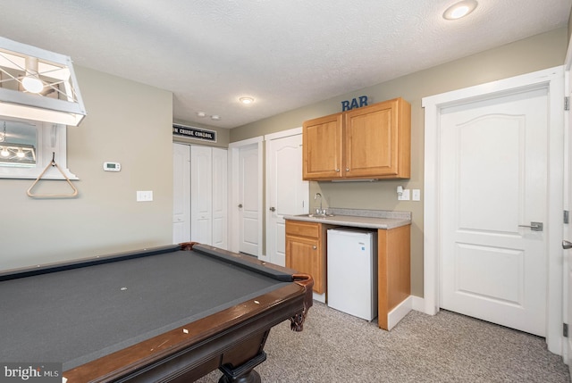 game room featuring pool table, light colored carpet, a sink, a textured ceiling, and wet bar