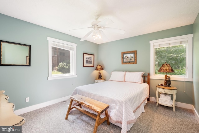 carpeted bedroom featuring a ceiling fan, visible vents, and baseboards