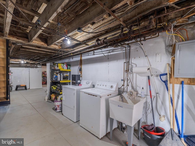 laundry area featuring electric panel, a sink, laundry area, and washing machine and clothes dryer