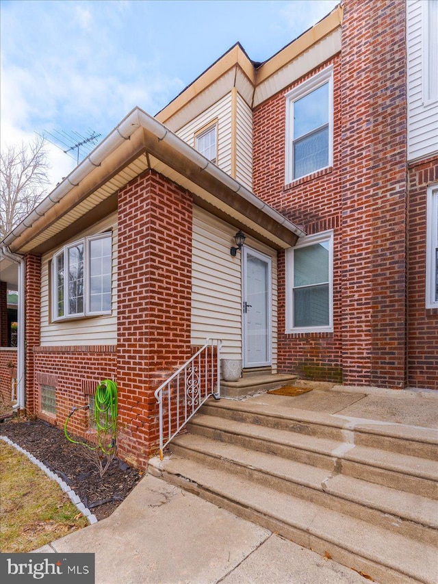 entrance to property featuring brick siding