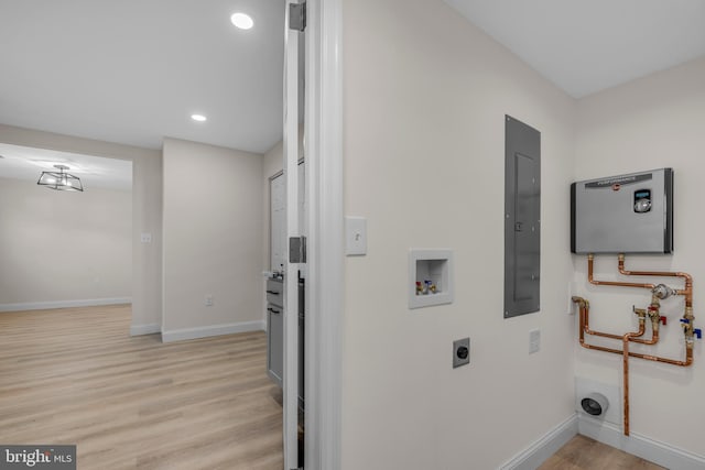 laundry room with electric panel, baseboards, light wood-style floors, and laundry area