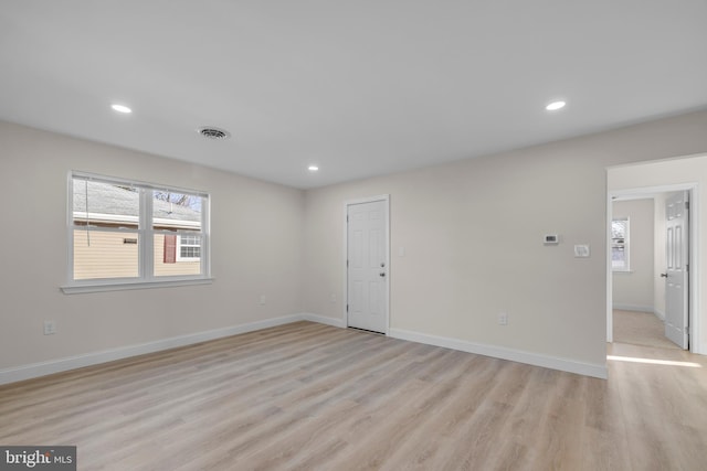 spare room with light wood-type flooring, visible vents, baseboards, and recessed lighting