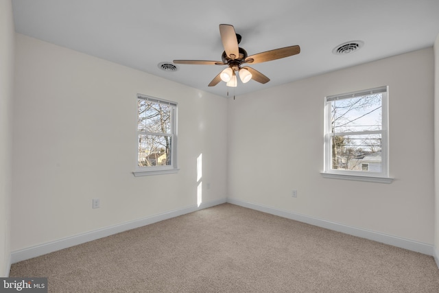 spare room featuring visible vents, carpet flooring, and a healthy amount of sunlight