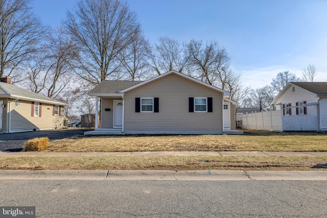 view of front of property featuring a front lawn and fence