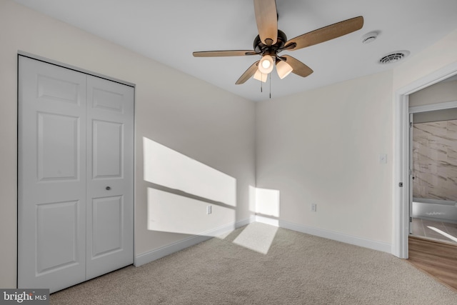 unfurnished bedroom featuring visible vents, a ceiling fan, a closet, carpet, and baseboards